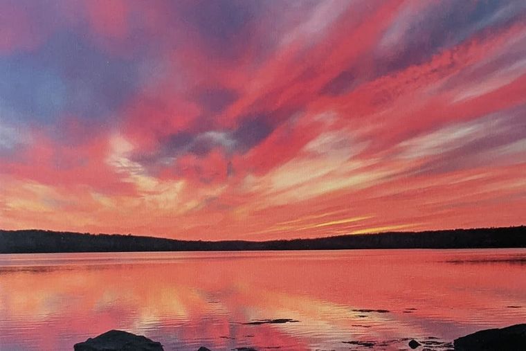 Dramatic rose and crimson sunset glowing over the still waters of Penobscot Bay.